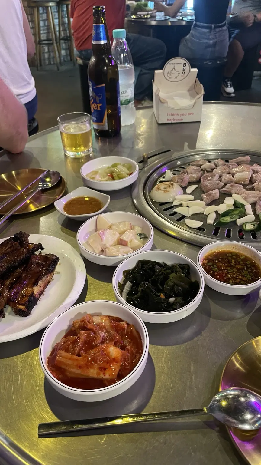 Koreanisches Barbecue mit Fleisch vom Tischgrill, Kimchi und verschiedenen Beilagen.
