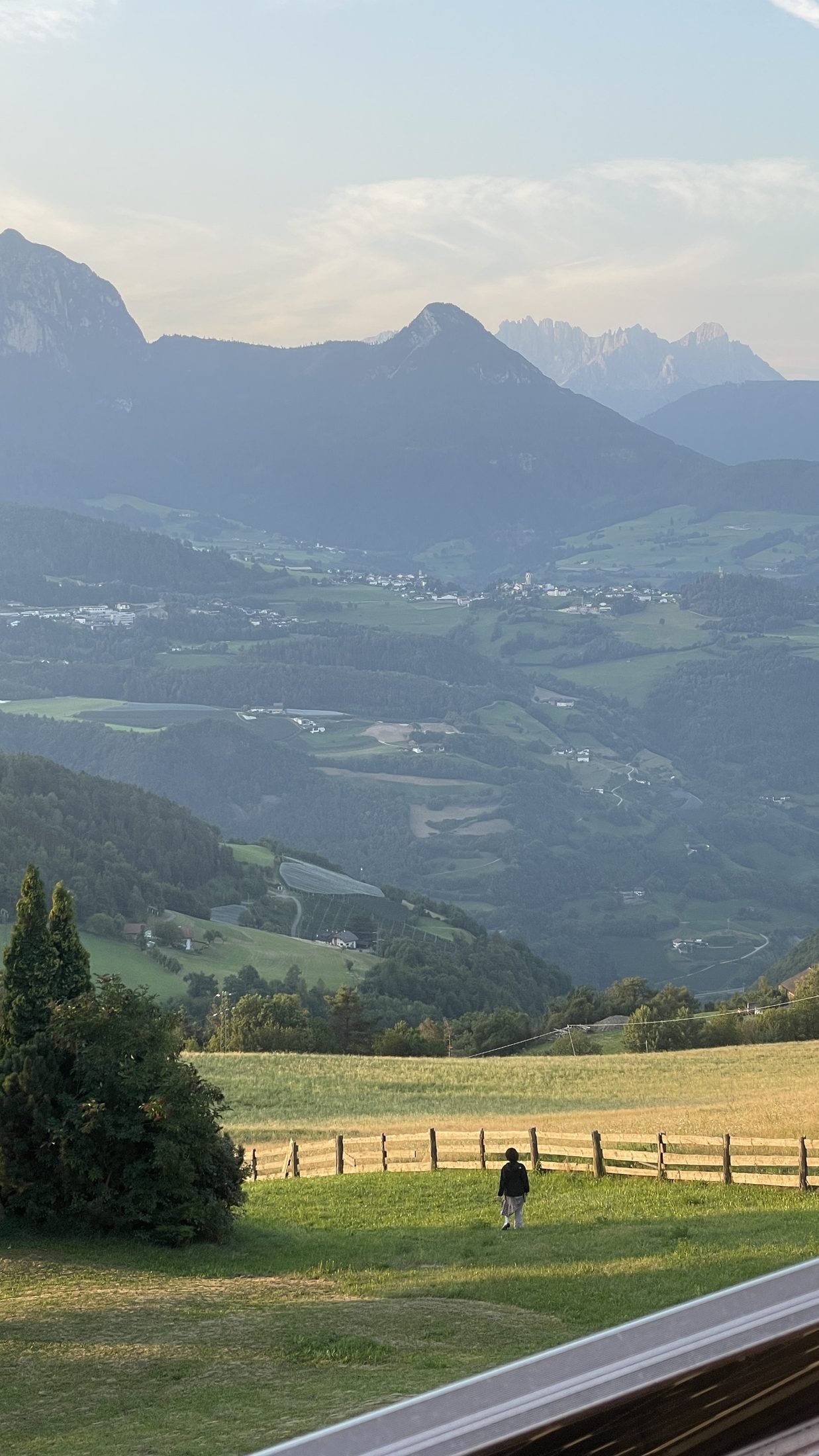 Blick vom Ritten über grüne Südtiroler Täler bis zu den Dolomitengipfeln