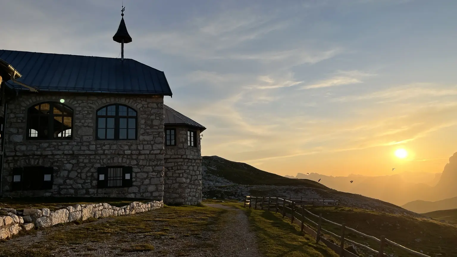 Das Schlernhaus mit seiner kleinen Kapelle im goldenen Licht der untergehenden Sonne.