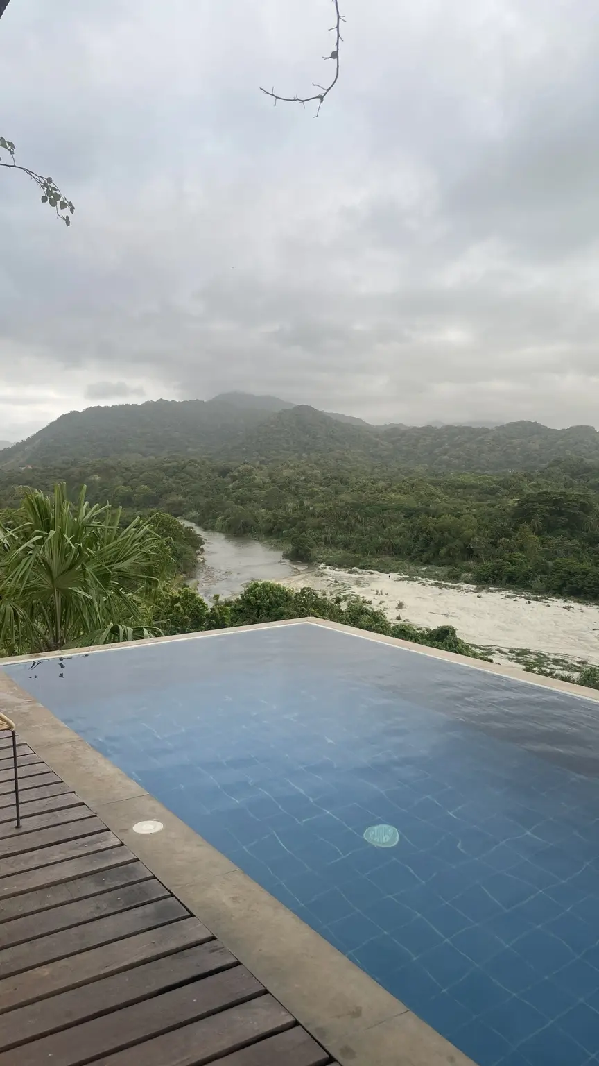 Infinitypool des Journey Hostels mit Blick über den Fluss und die grünen Hügel bei Tayrona