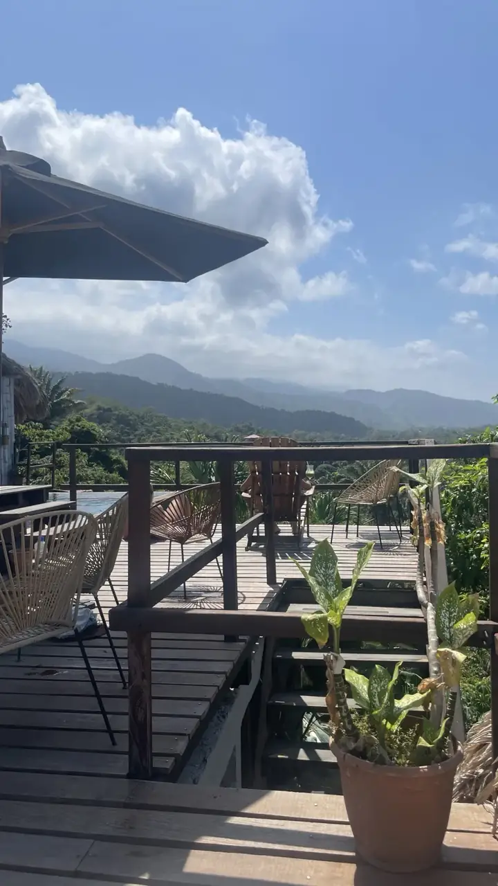 Terrasse des Journey Hostels mit Sitzplätzen und Blick über die grünen Hügel