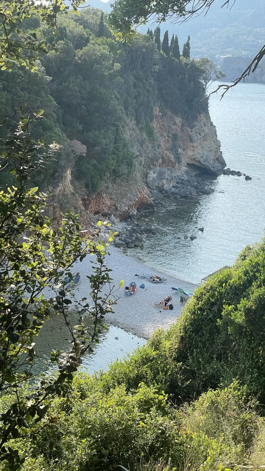Kleine Kiesbucht zwischen bewachsenen Felsen auf Korfu