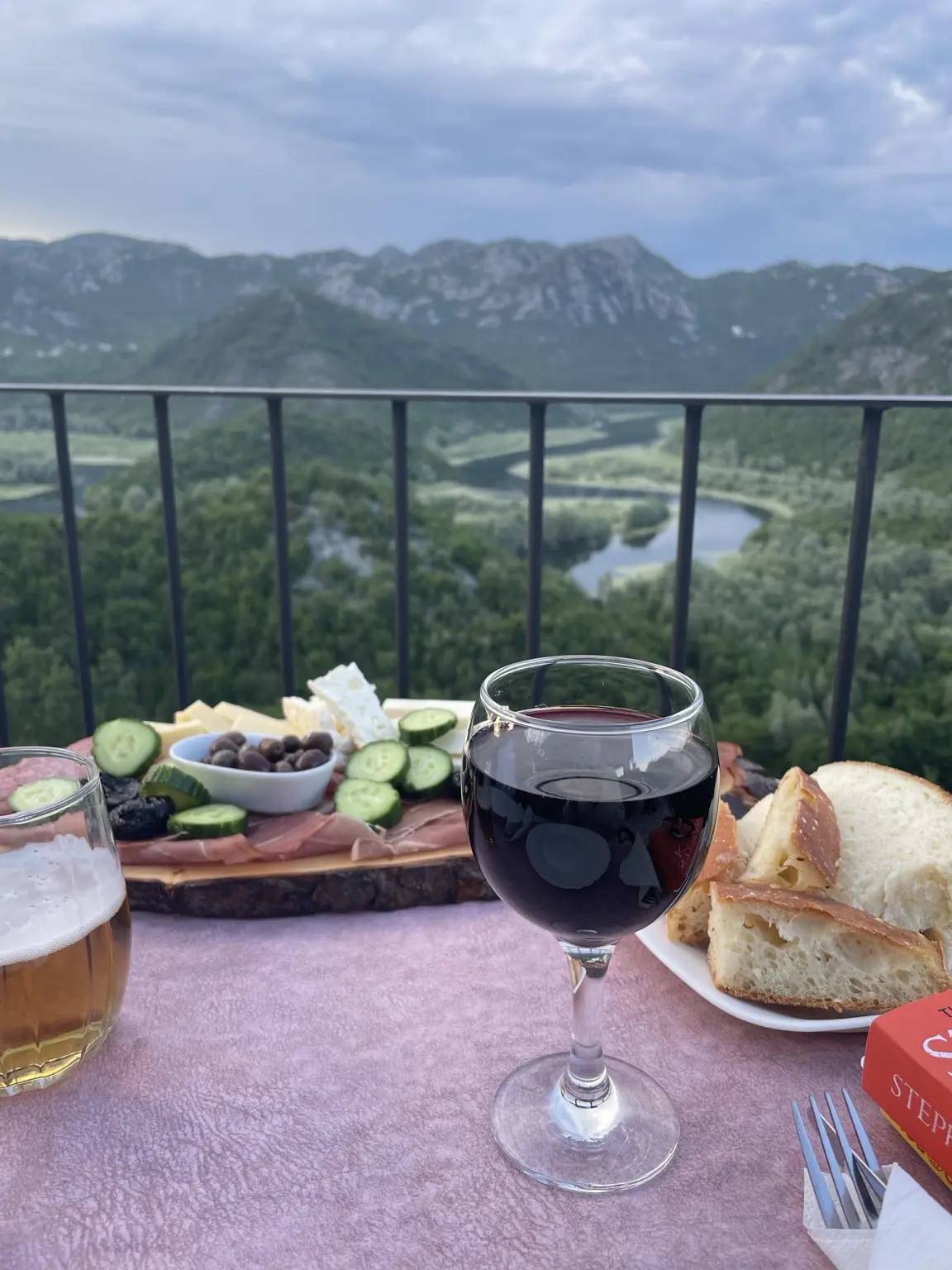 Brot, Käse, Oliven und Wein auf einer Terrasse mit Blick auf die Flussschleifen der Rijeka Crnojevića