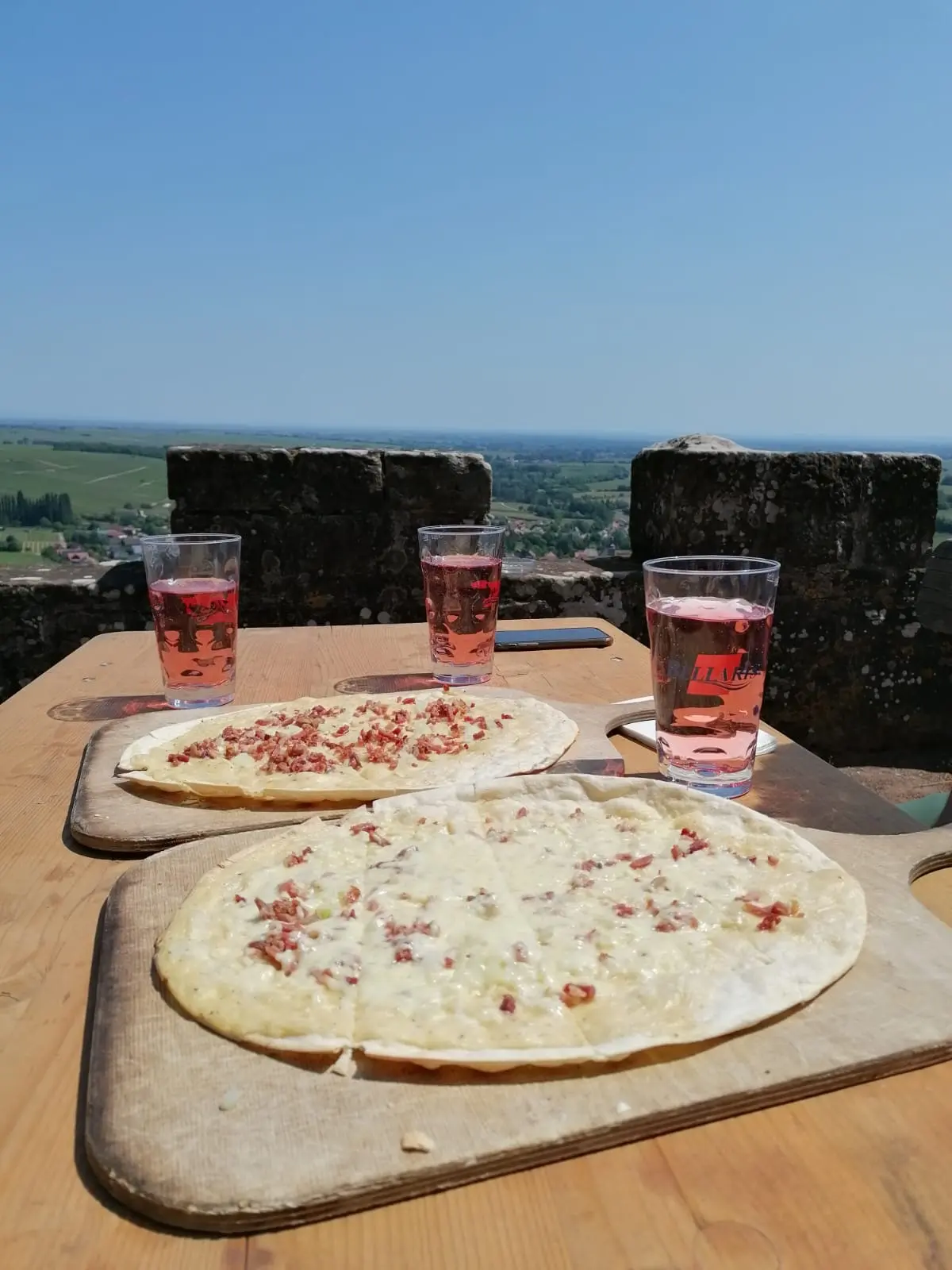 Zwei Flammkuchen und drei Pfälzer Schorlen auf einer Burgterrasse mit weiter Aussicht